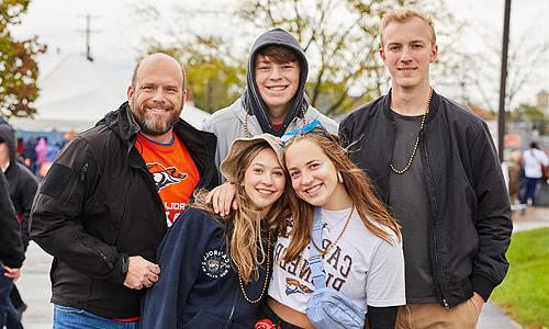 Father with smiling family of children wearing Carroll University t-shirts